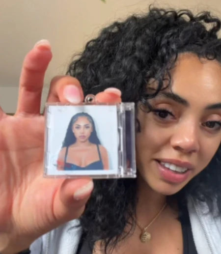 A woman holding an Album Tag with portrait artwork